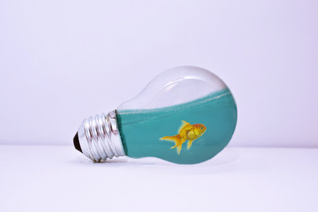 Yellow fish in a lightbulb on a white background. Idea conceptの写真素材