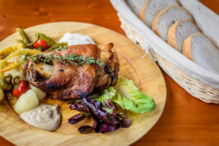 roasted duck with potatoes and pickled cucumbers on wooden plateの写真素材