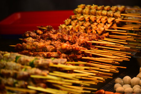 Grilled meat on skewers at street food market in Thailand.の写真素材