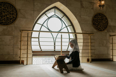 Muslim woman reading Koran in mosque, Ramadan Kareem. Muslim woman praying in mosque
