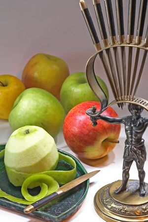 Green and red apples with a fruit knife and antique knife stand の写真素材