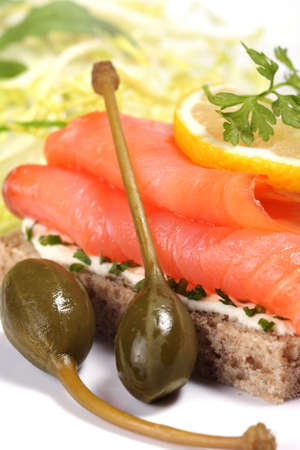 Smoked salmon sandwich with green salad, fresh aromatic herbs and capersの写真素材
