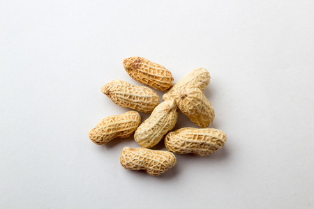 A group of Peanuts in shell closeup white background.の写真素材