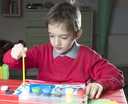 young boy is painting a paint. chaild painter in a room.の写真素材