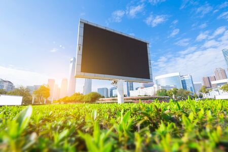 Big white blank billboard in modern city over blue sky background.の写真素材