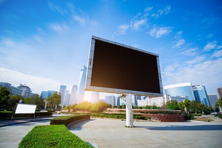 Big white blank billboard in modern city over blue sky background.の写真素材