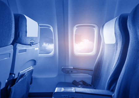 View of the sky and clouds with sunlight from the airplane window,empty seats.の写真素材