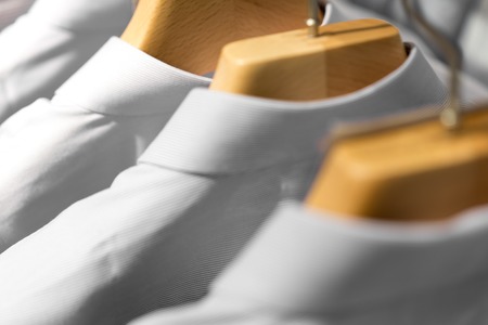 White Fashionable clothes on hangers in storeの写真素材