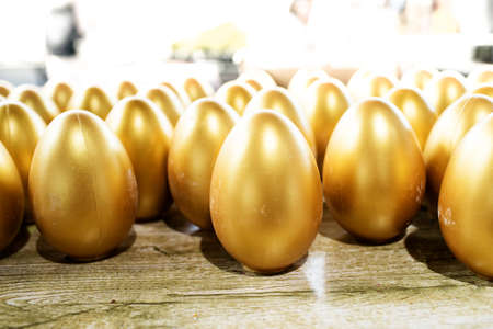 Easter eggs covered in gold in the basketの写真素材
