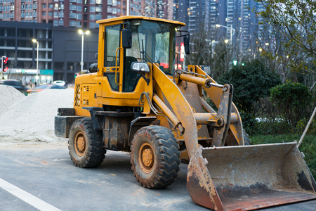 Old yellow bulldozer with caterpillar moving ground with scoop.のeditorial素材