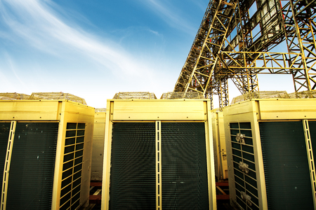 Industrial air conditioner condensers (outside unit) on the roof of a building on a hot summer dayの写真素材