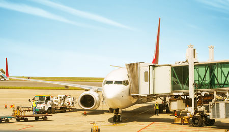 Airplane near the terminal in an airport at the sunsetのeditorial素材