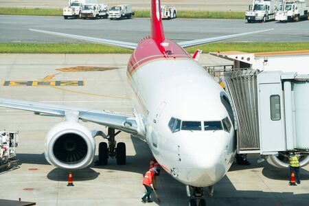 Airplane near the terminal in an airport at the sunsetのeditorial素材