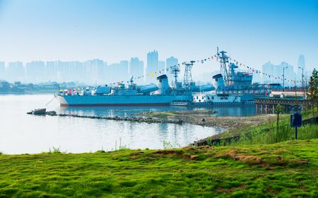 Grey modern warship sailing in still water against dramatic skyの写真素材