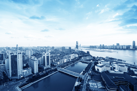 suspension bridge and modern residential district near haihe river in tianjin in blue cloud skyの写真素材