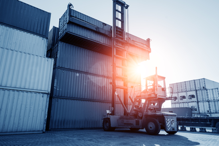 Crane lifting up container in yardの写真素材