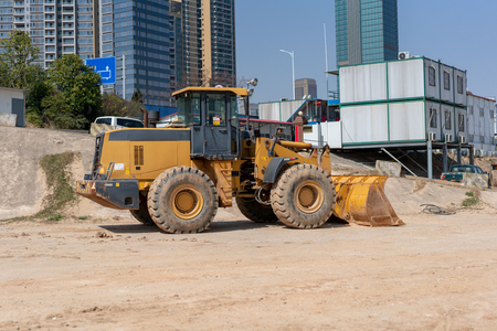 industrial building construction site mini bulldozer levelling and moving soil during highway buildingの写真素材