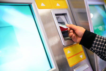 male hand businessman inserts credit card into the ATM and withdraws moneyの写真素材
