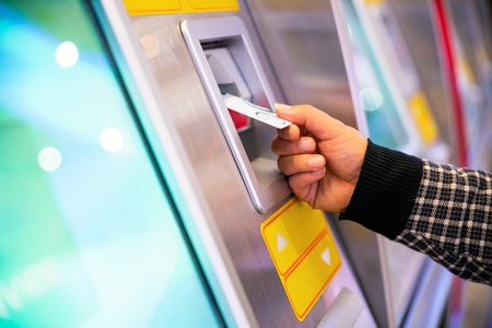 male hand businessman inserts credit card into the ATM and withdraws moneyの写真素材