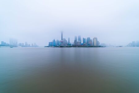The modern buildings of Lujiazui and Huangpu river with sunrise glow in Shanghai, China.の写真素材