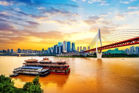 cityscape and skyline of downtown near water of chongqing at sunsetの写真素材