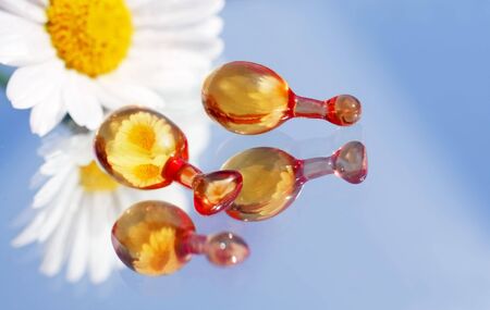 Two capsules on a mirror with marguerite