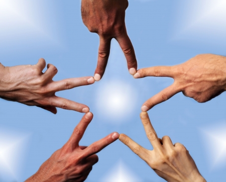 Five hands with different skin-color, their fingers building a star