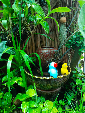 Tropical garden with green plants and birds in a pot.の写真素材