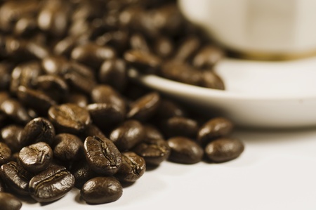 Coffee beans on white background by saucer cupの写真素材