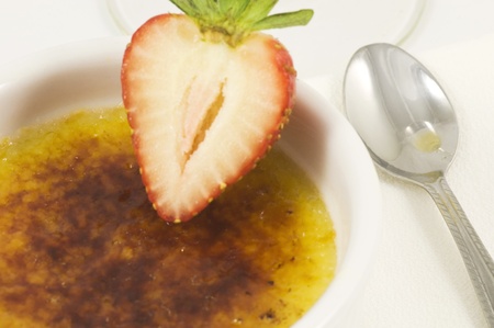close up of creme brulee with spoon and garnishの写真素材