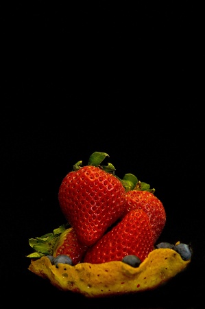strawberries in ginger bread snap cookie basket on dark backgroundの写真素材