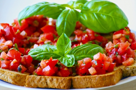 Crusty bruschetta with fresh diced tomatoes, garlic and basil is a popular Italian antipasto served in most retaurantsの写真素材