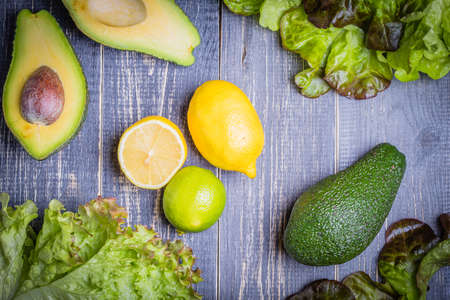set of salad - lettuce mix, avocado, lemon, lime on a dark backgroundの写真素材