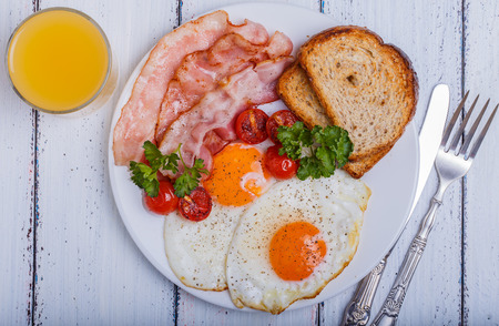 tasty dish with the traditional bacon and eggs served with toastの写真素材