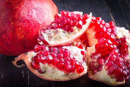 juicy pomegranate and pomegranate parts on a black backgroundの写真素材