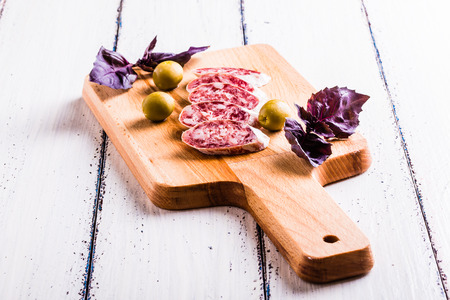 Slices of salami on a cutting board in a rustic styleの写真素材
