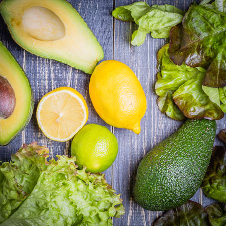 Set of salad - lettuce mix, avocado, lemon, lime on a dark backgroundの写真素材