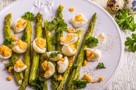 Grilled asparagus with quail eggs on a white wooden backgroundの写真素材