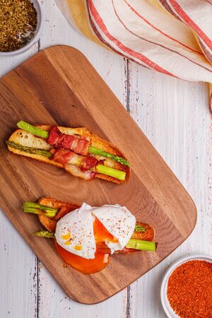 Bruschetta with grilled asparagus, bacon and poached eggs.の写真素材
