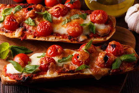 Pizza margarita with mozzarella and cherry tomatoes, basil on a baguette, selective focus.の写真素材