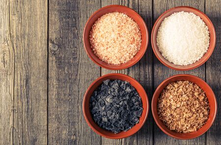 Variety of Different Sea Salts in ceramic bowls on dark background.の写真素材