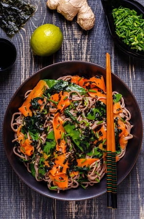 Soba noodles with vegetables and seaweed, top view.の写真素材