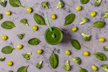 Green smoothie with ingredients on  concrete surface, top view.の写真素材