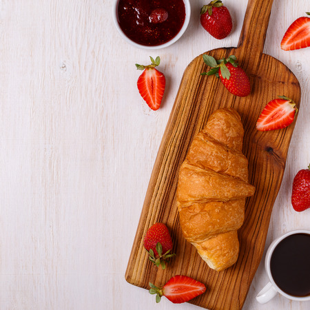 Breakfast with croissant, jam, fruit and coffee, top view.の写真素材