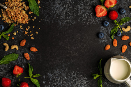 Tasty ingredients (granola, berries, milk and nuts) for breakfast, top view. Healthy food, Diet, Detox, Clean Eating or Vegetarian concept.の写真素材