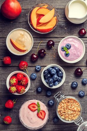 Homemade yogurt on a wooden background, top view. Healthy food, Diet, Detox, Clean Eating or Vegetarian concept.の写真素材