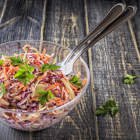 Homemade coleslaw in bowl on dark wooden background, selective focus.の写真素材