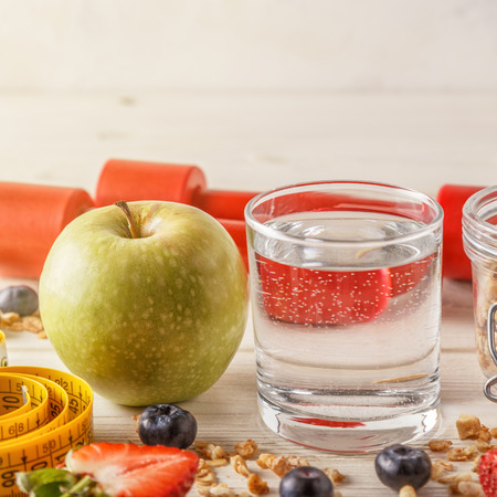Healthy breakfast, dumbbells and measuring tape on wooden background, selective focus.の写真素材