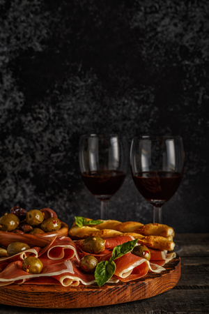 Prosciutto, cracker, bread sticks with red wine, selective focus.の写真素材