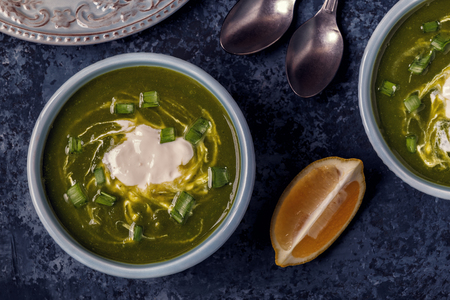 Bowls with green soup of broccoli, spinach and green pea, top view.の写真素材